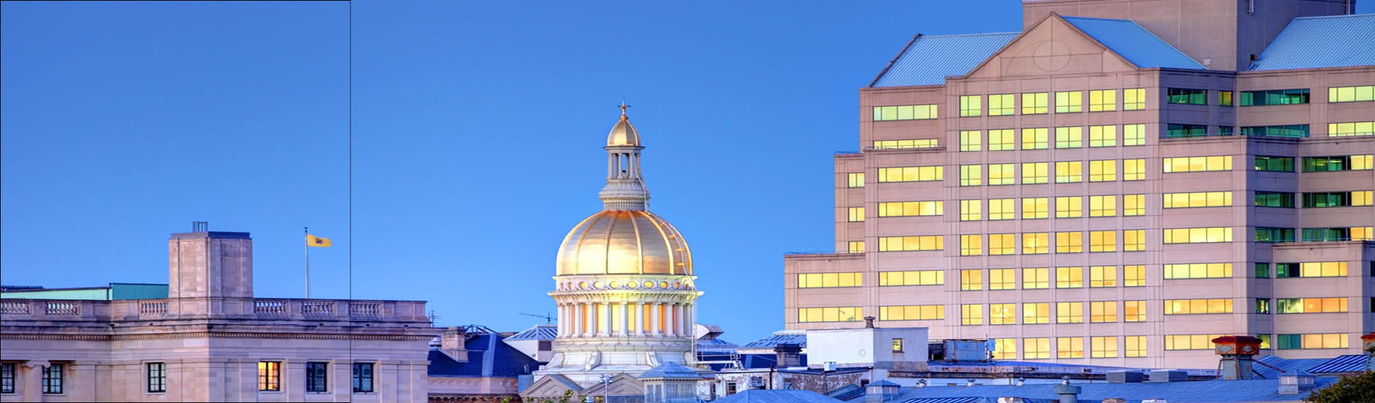 An aerial view of the Statehouse and Department of the Treasury at dusk.